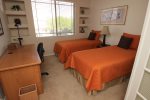 Guest bedroom offers two twin beds and desk work area